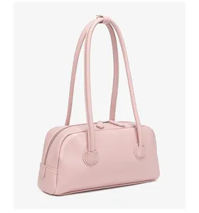 Primer plano del bolso bowling rosa con textura suave y detalle de cremallera doble