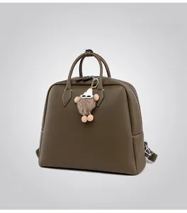 Dettaglio della pelle martellata verde militare e ciondolo di peluche sulla borsa
