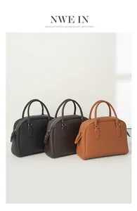 Close-up of three leather tote bags in black, brown, and tan with pebbled texture