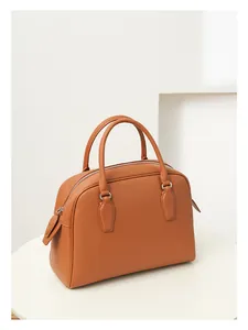 Detailed close-up of caramel Boston bag showing premium litchi grain texture and handles