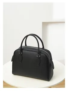 Detail of black pebbled leather texture on a large tote bag with silver hardware