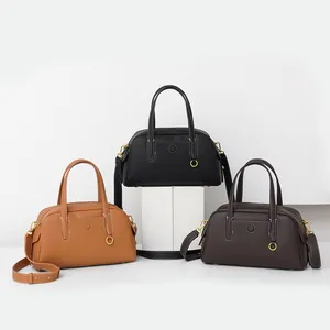 Detalle de bolsos tote de cuero en marrón, negro y café con costuras en contraste