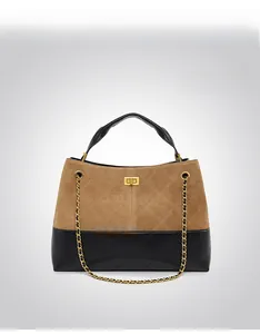 Detail of a brown frosted leather and black quilted handbag with a gold twist lock