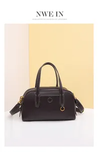 Detalle de bolso en cuero granulado con costuras en contraste y herrajes dorados