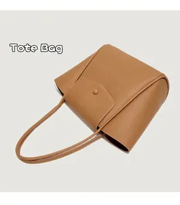 Dettaglio della borsa tote in pelle marrone con grana e patta con fibbia magnetica