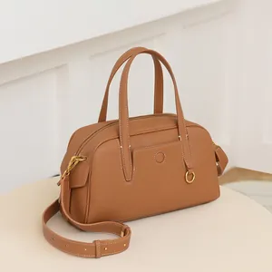 Vista lateral del bolso Boston en cuero color caramelo con herrajes dorados