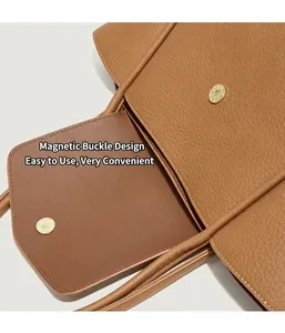 Dettaglio della borsa in pelle marrone martellata con chiusura magnetica dorata e cuciture