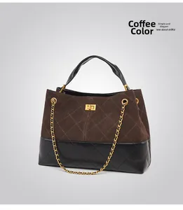 Detail of coffee suede and black leather quilted bag with gold twist lock and chain