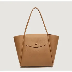 Dettaglio della borsa tote marrone caramello con trama in pelle a grana litchi