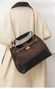 Detail of vintage matte tote bag with contrasting quilting and metal turn-lock