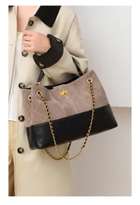 Close-up of contrast patchwork tote with quilted suede and golden twist lock
