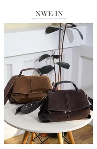 Detail of matte suede handbags in dark brown and caramel with contrast stitching
