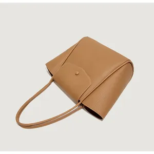 Dettaglio borsa tote in pelle marrone martellata con patta e bottone a pressione