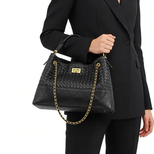 Detail of woven texture, quilted leather pattern and gold buckle on black shoulder bag