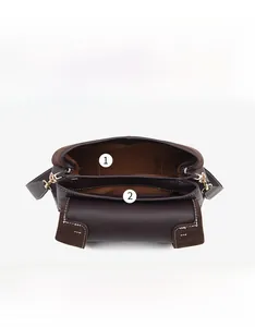 Detail view of the brown leather handbag interior with main bag and inner sticker pocket