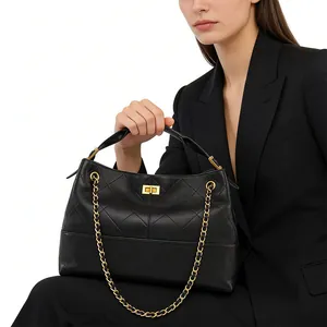 Detail of black quilted leather bucket bag featuring gold twist lock and chain strap