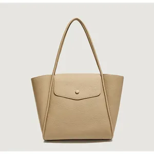 Dettaglio della borsa tote beige con pelle a grana fine e patta con bottone