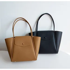 Dettaglio di borse tote in pelle martellata marrone e nera con chiusura a scatto in metallo