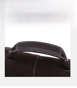 Close-up of contrast stitching on dark brown leather handle and suede texture bag
