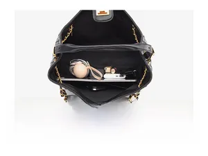 Top view showing main compartment capacity of black woven leather tote with daily items