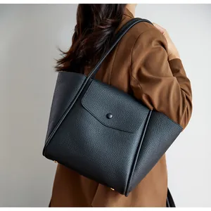 Dettaglio della borsa tote in pelle martellata nera con vista laterale e piedini dorati