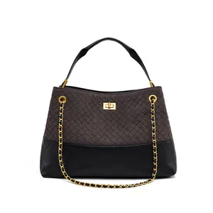 Detail of grey woven fabric and black quilted leather handbag with gold twist lock
