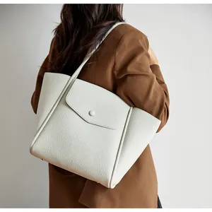 Dettaglio della trama litchi della borsa tote in pelle bianca con chiusura a fibbia