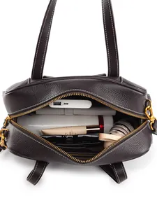 Bolso tote de cuero marrón con gran capacidad mostrando objetos cotidianos organizados