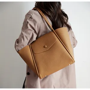 Dettaglio borsa shopper color caramello con trama martellata e piedini di protezione