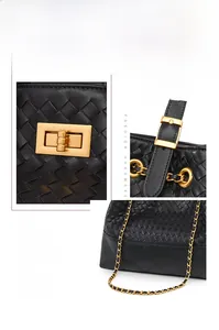 Detail of black woven leather tote with matte gold twist lock and adjustable chain strap
