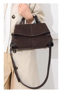 Deep brown suede and leather handbag with contrast stitching worn with a beige trench coat