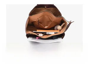 Spacious interior of dark brown tote bag showing compartments and daily essentials