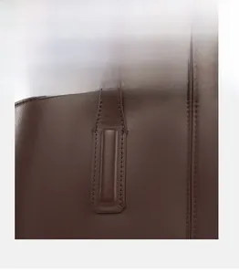 Detail of the reinforced stitching on dark brown leather tote handles for heavy weight