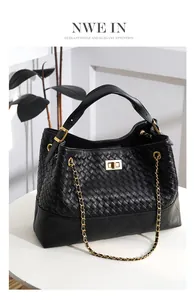 Detailed close-up of woven black leather texture and gold metal twist lock on a handbag