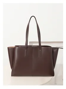 Detail showing deep brown leather tote bag with vertical stitch and gold zipper
