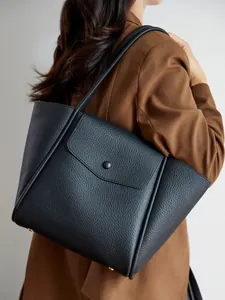 Borsa tote minimalista in pelle nera con motivo litchi e grande capacità indossata
