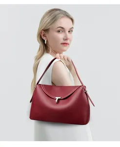 Detail of burgundy leather handbag featuring white contrast stitching and silver T-buckle