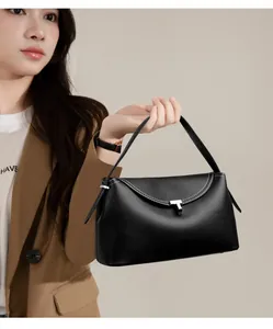 Detail of black lychee leather handbag with silver T-buckle and white contrast stitching