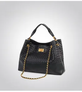 Detail of hand-woven bucket bag with quilted stitching and gold chain strap