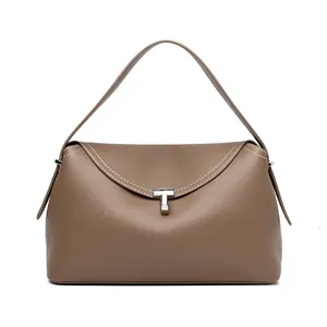 Detail of taupe pebbled leather handbag with white stitching and T-shaped metal clasp