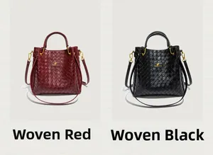 Détail de sacs seaux tressés en rouge foncé et noir avec ferrures dorées