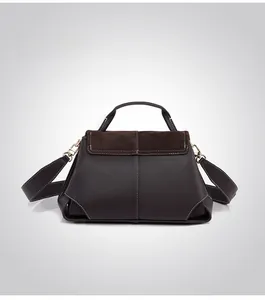 Detail view of the dark coffee leather handbag back with contrasting suede and gold hardware