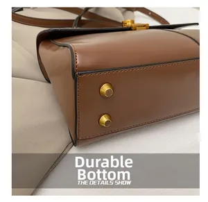 Gros plan d'un sac cabas en cuir marron avec clous dorés protecteurs sur le fond résistant