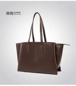 Macro view of stitching details and leather texture on a dark brown tote bag