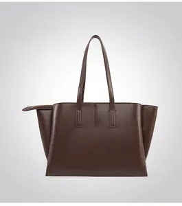 Detail view of the structured back and smooth matte texture of this brown leather tote bag