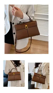 Détail du sac à main en cuir marron foncé avec boucle dorée et bandoulière réglable