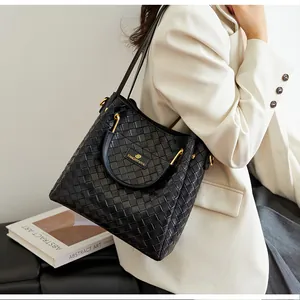 Détail du grand sac cabas noir tissé avec garnitures métalliques et texture de cuir