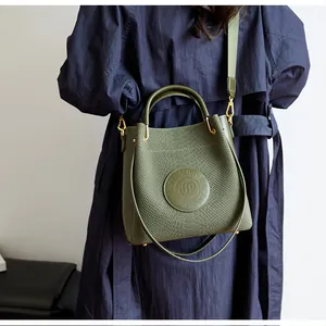 Vue détaillée du sac seau vert foncé effet serpent avec une large bandoulière