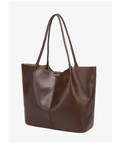 Macro detail of dark brown tote bag showing glossy leather texture and stitching