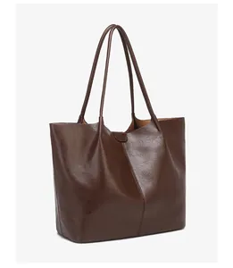 Detail of dark brown tote bag showing smooth oil wax leather texture and side stitching